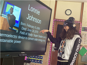 A student presents what she learned about Lonnie Johnson during a class presentation on Black contributors to STEM fields.